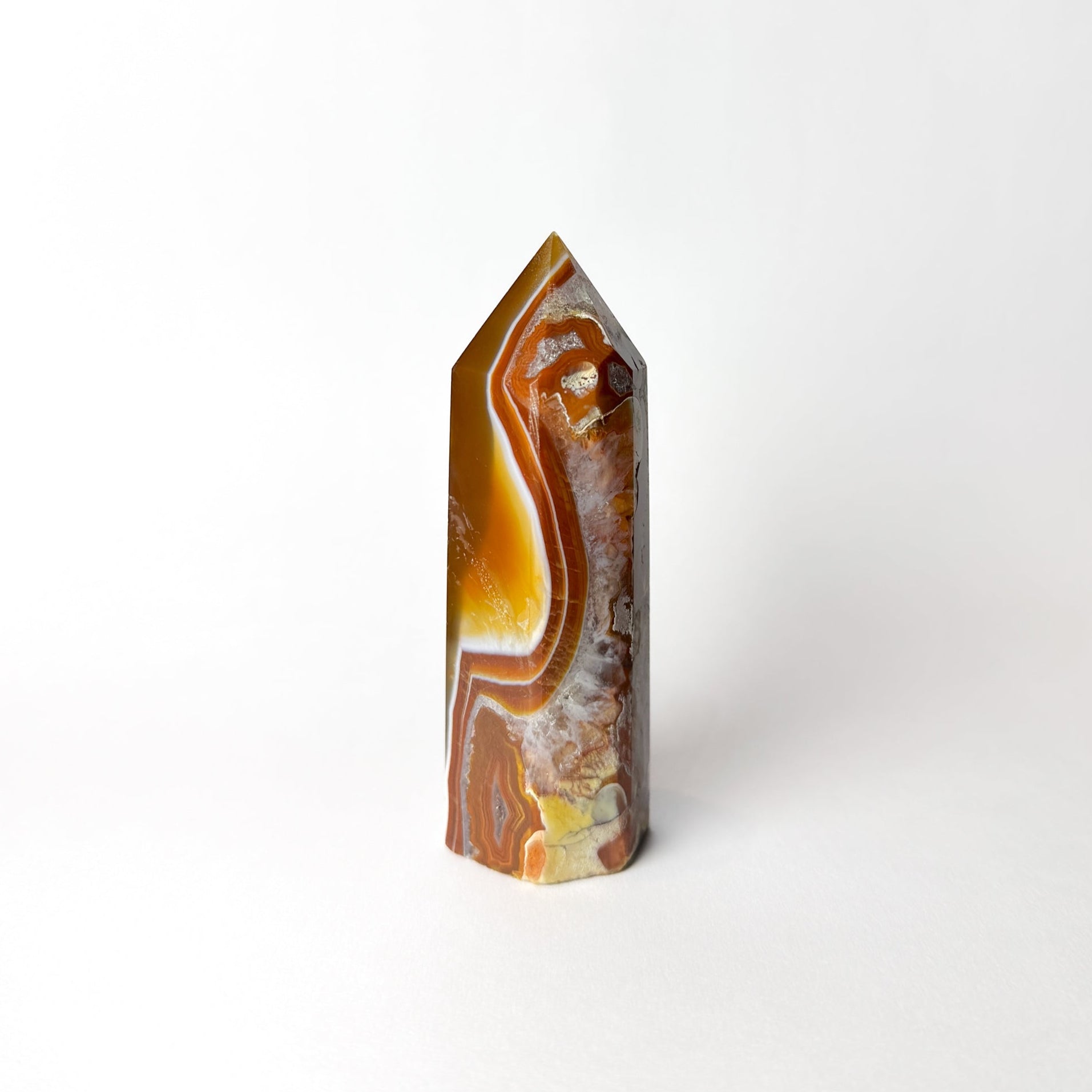 Agate crystal with brown and yellow patterns on a white background